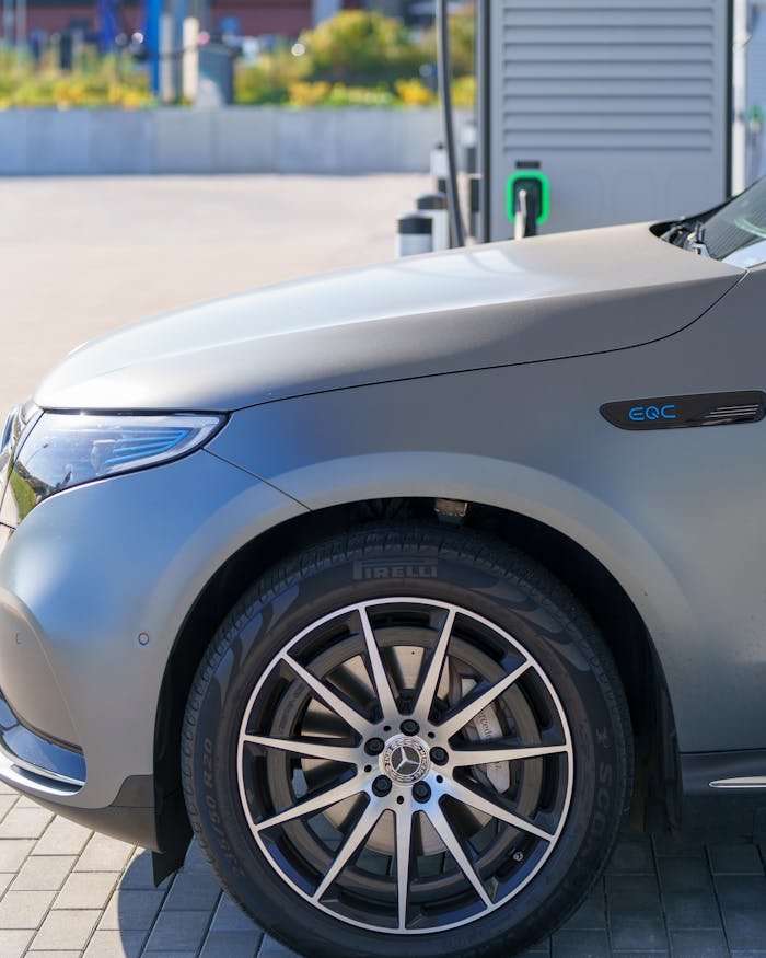 Close-up of an electric car at a charging station with clear blue skies and modern design.